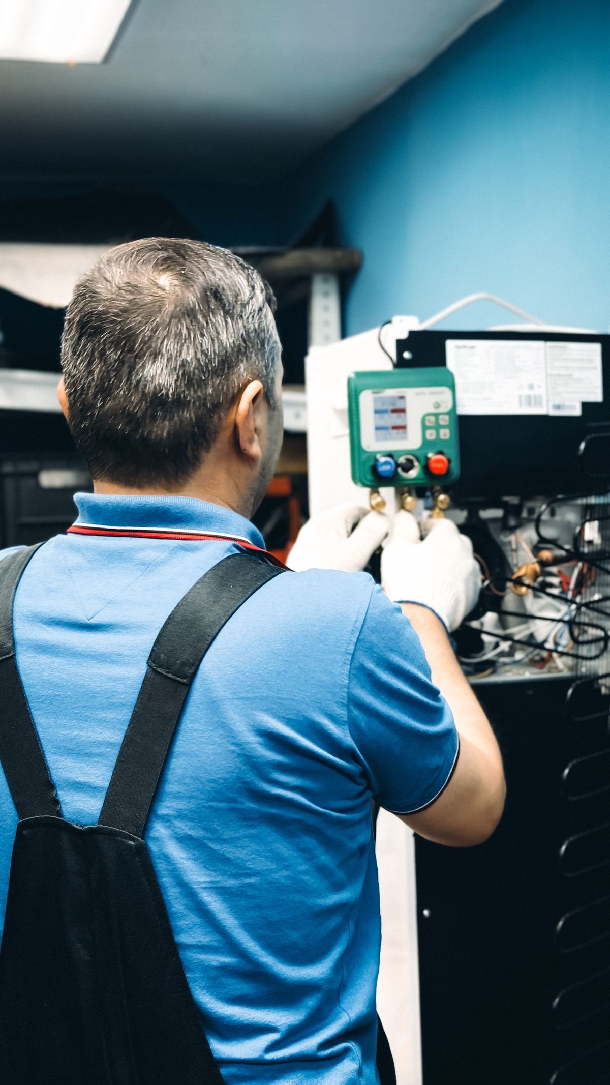 HVAC service technician using pressure gauges to service a cooling system