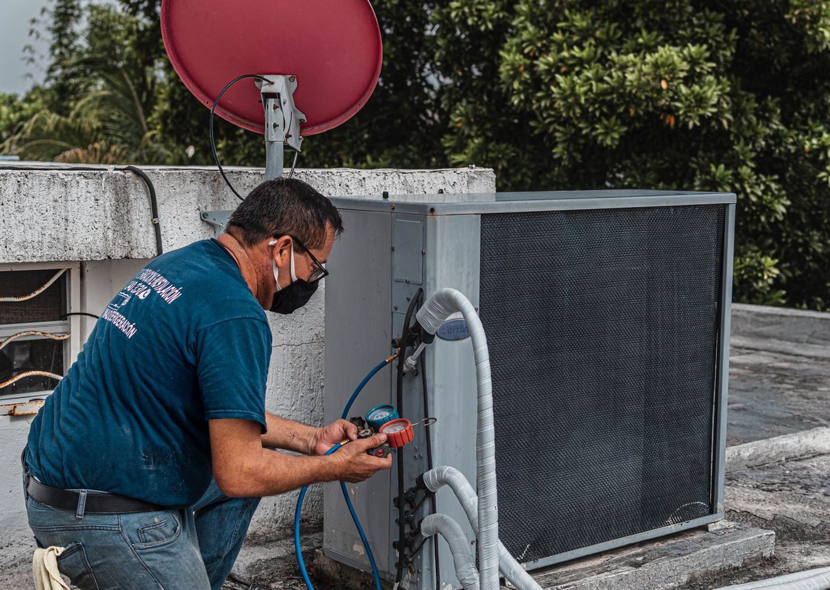 HVAC technician working on an outdoor condenser unit on a service call