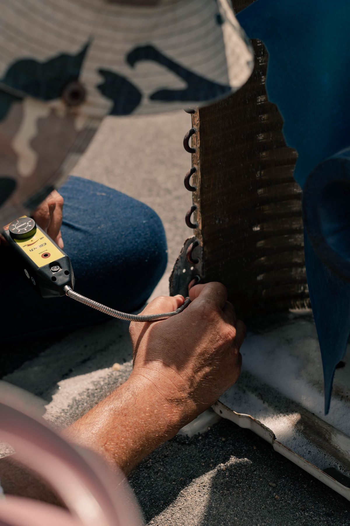 HVAC technician inspecting condenser coils during a seasonal maintenance tune-up