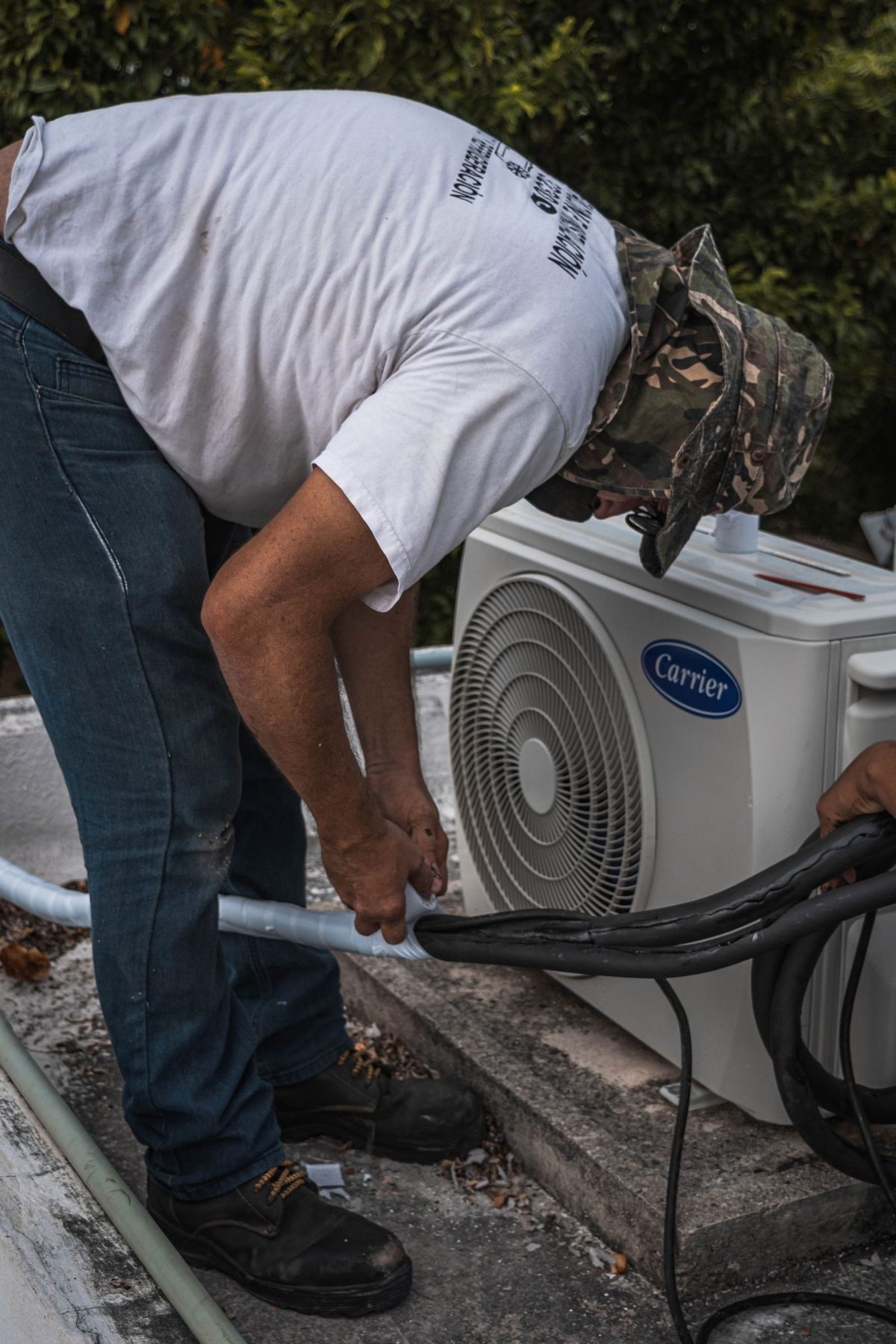 HVAC technician troubleshooting the refrigerant line on an outdoor air conditioning unit